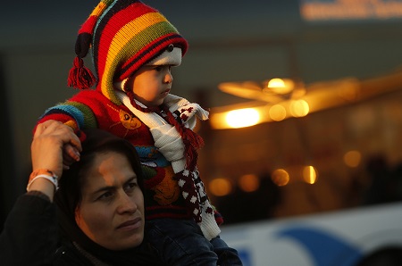 A migrant carries a baby on her shoulders after refugees and migrants arrived on the passenger ferry Blue Star1 at the port of Piraeus, near Athens, Greece, January 31, 2016. Photo: Darrin Zammit Lupi