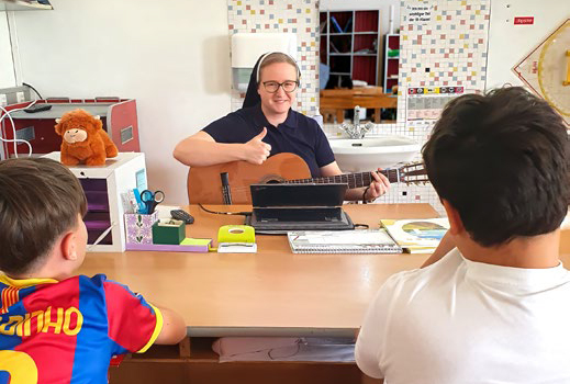 Wenn der Funke überspringen soll, hilft manchmal auch die Gitarre: Sr. Sabine Grangl mit ihren Schülerinnen und Schülern