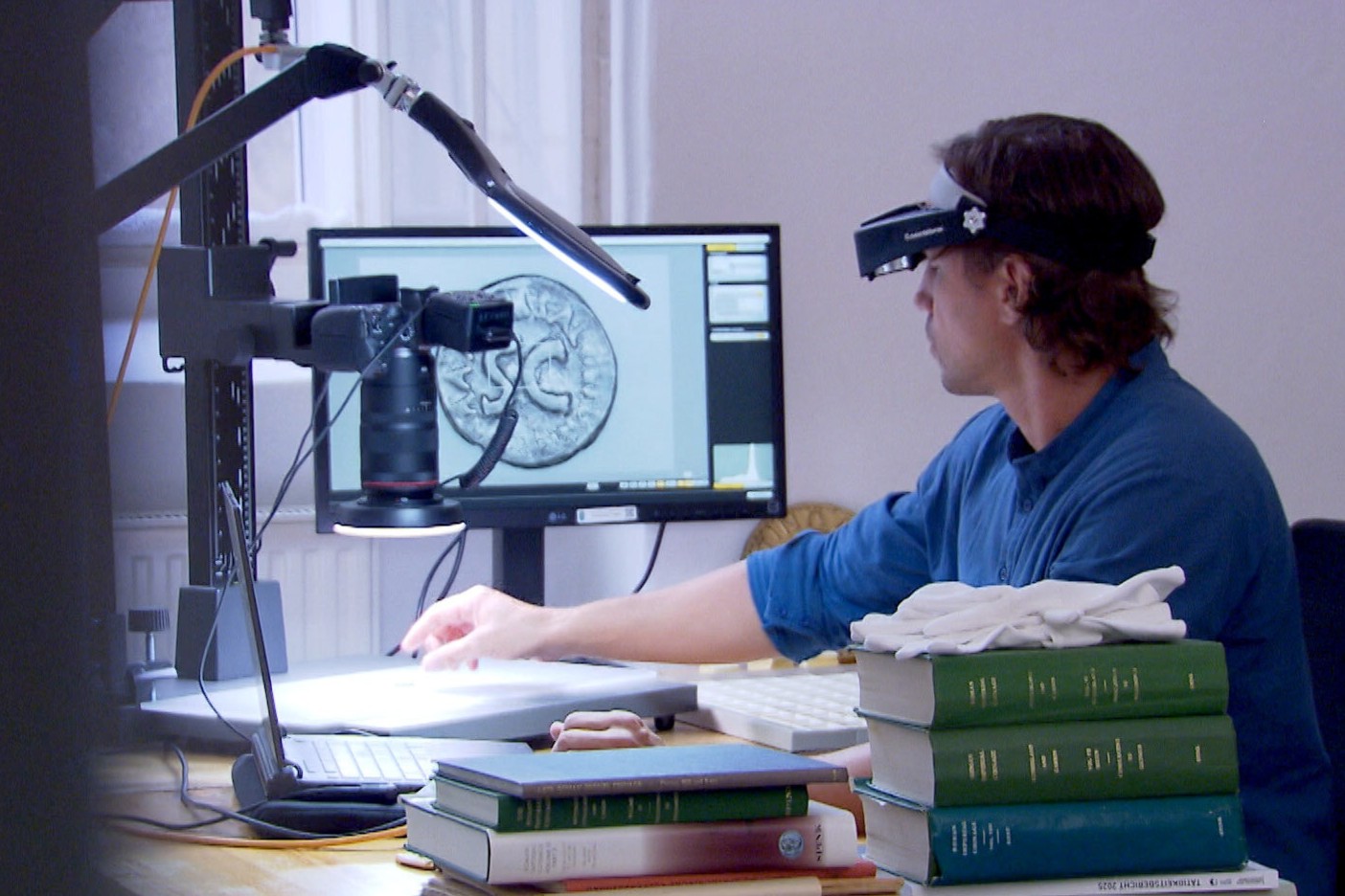 Martin Baer, Münzexperte, Universität f. Weiterbildung Krems, beim Digitalisieren v Münzen. / ORF/Landesstudio Niederösterreich Erlebnis Österreich - Digitale Klöster und Kirchen - Tradition im Wandel - Niederösterreich verfügt über eine einzigartige Klosterlandschaft und ein reiches sakrales Kulturerbe. Jahrhundertealte Handschriften, Bibliotheken und sakrale Bauwerke sind Z