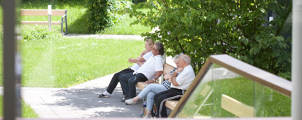 Das Foto zeigt Menschen auf einer Parkbank