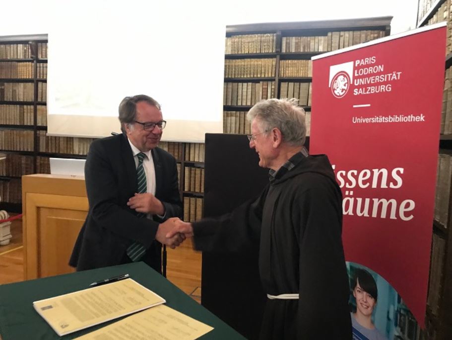 Mit Unterschrift und Handschlag besiegelt: Hendrik Lehnert, Rektor der Universität Salzburg, und Bruder Erich Geir, Delegat der Kapuzinerdelegation Tirol.