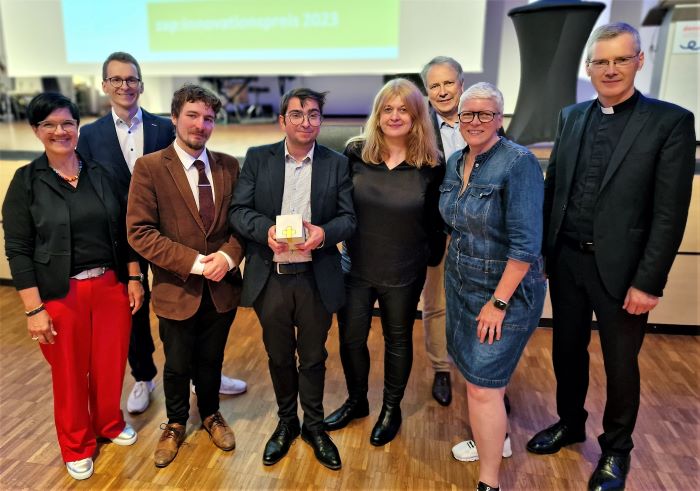 Freudiger Moment: Christopher Paul Campbell (4.v.l.) und Marius S. Binder (3.v.l.) vom Quo vadis? inmitten der Jury und des zap-Teams.