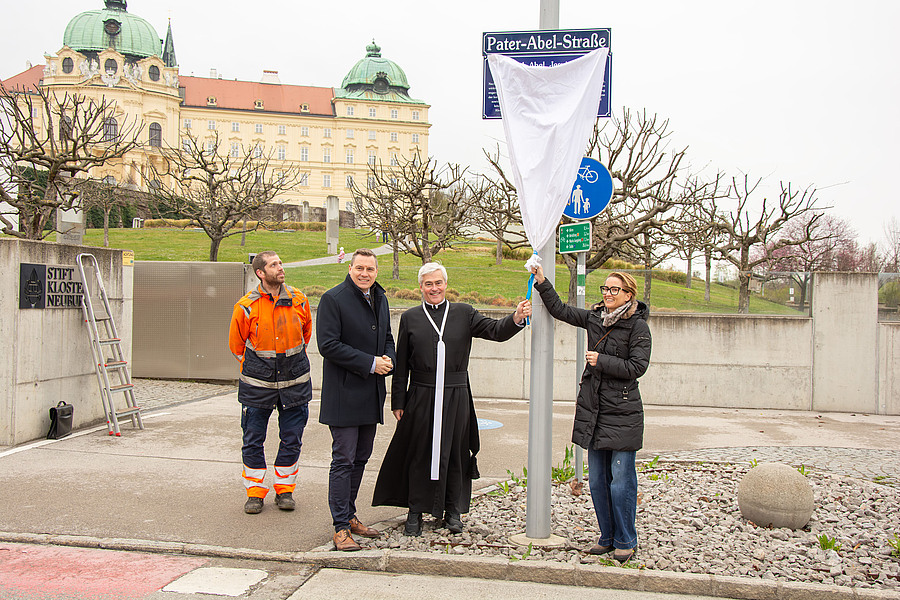 Bürgermeister Christoph Kaufmann, Stiftskämmerer Elias Carr Can.Reg. und Kulturstadträtin Katharina Danninger (v.l.) enthüllten die Zusatztafel an der Pater-Abel-Straße in Klosterneuburg.
